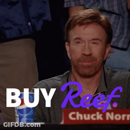 A Man With A Beard Is Sitting In Front Of A Sign That Says Buy Reef GIF
