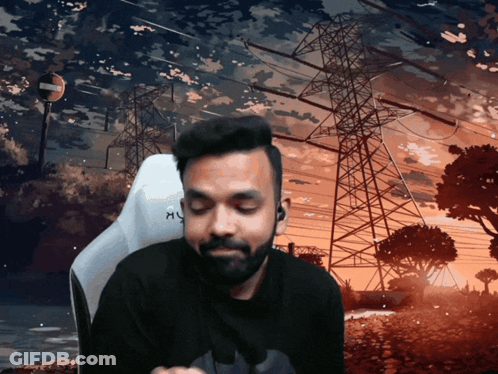 A Man With A Beard Is Sitting In Front Of A Sunset With A Sign That Says No Entry GIF