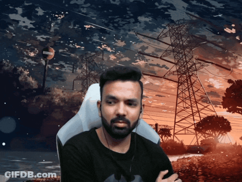 A Man With A Beard Is Sitting In Front Of A Sunset With Power Lines In The Background GIF