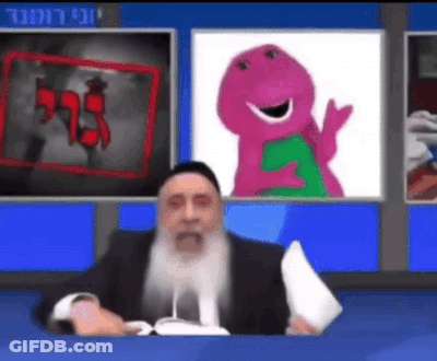 A Man With A Beard Is Sitting In Front Of A Television With A Picture Of Barney On The Screen . GIF