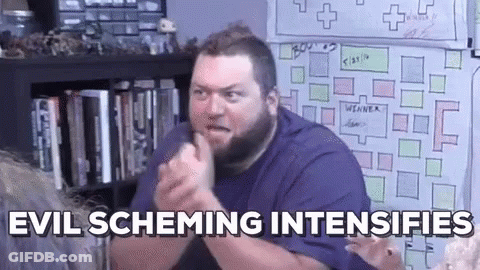 A Man With A Beard Is Sitting In Front Of A White Board And Making A Funny Face . GIF