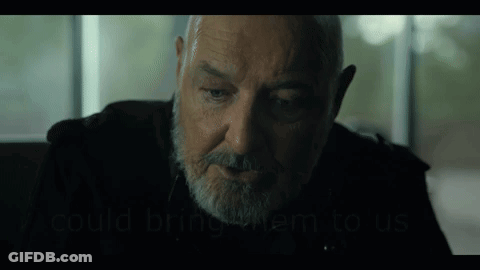 A Man With A Beard Is Sitting In Front Of A Window And Talking To Someone . GIF