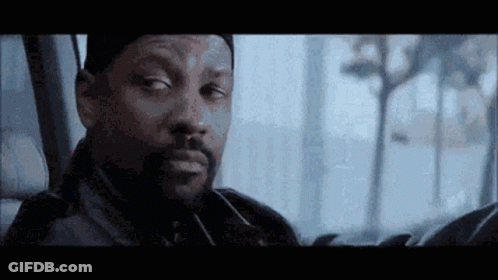 A Man With A Beard Is Sitting In The Back Seat Of A Car Looking Out The Window . GIF
