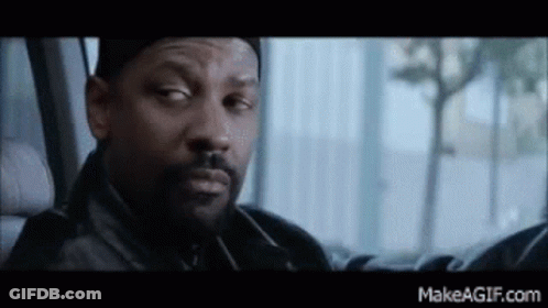 A Man With A Beard Is Sitting In The Back Seat Of A Car Looking Out The Window . GIF