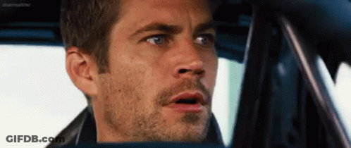 A Man With A Beard Is Sitting In The Driver 'S Seat Of A Car . GIF