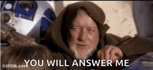 A Man With A Beard Is Sitting Next To A Robot And Says `` You Will Answer Me '' . GIF
