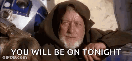 A Man With A Beard Is Sitting Next To A Robot . GIF