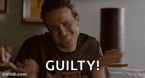 A Man With A Beard Is Sitting On A Bed With His Hands Outstretched And The Words `` Guilty ! '' GIF