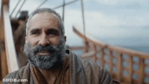 A Man With A Beard Is Sitting On A Boat GIF