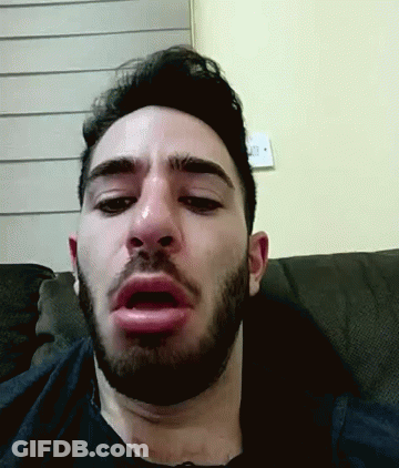 A Man With A Beard Is Sitting On A Couch And Making A Funny Face GIF
