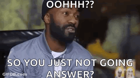 A Man With A Beard Is Sitting On A Couch And Making A Funny Face While Talking To Someone . GIF