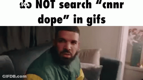 A Man With A Beard Is Sitting On A Couch In A Living Room And Looking At The Camera . GIF