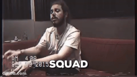 A Man With A Beard Is Sitting On A Couch With A Glass Of Beer In His Hand . GIF
