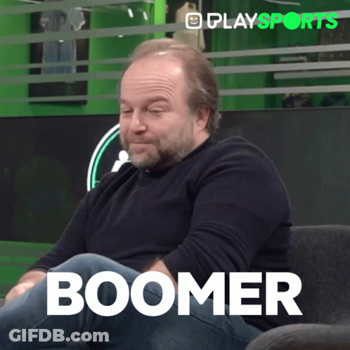 A Man With A Beard Is Sitting On A Couch With The Word Boomer Written On The Bottom GIF