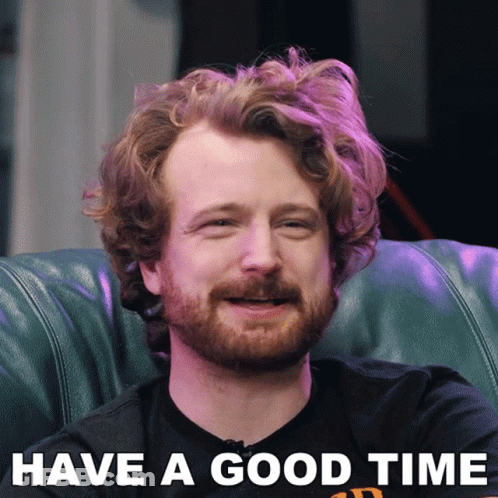 A Man With A Beard Is Sitting On A Couch With The Words Have A Good Time Above Him GIF
