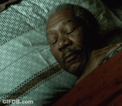 A Man With A Beard Is Sleeping In A Bed GIF