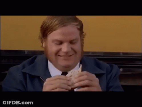 A Man With A Beard Is Smiling And Eating A Sandwich GIF