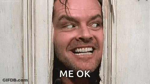 A Man With A Beard Is Smiling And Looking Through A Door . GIF