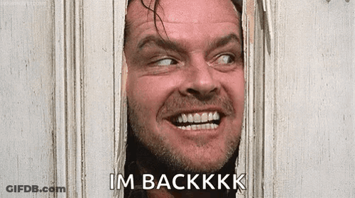 A Man With A Beard Is Smiling And Looking Through A Hole In A Door . GIF