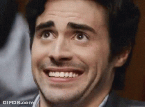 A Man With A Beard Is Smiling And Looking Up At Something GIF