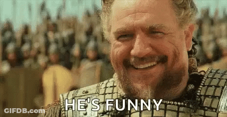 A Man With A Beard Is Smiling And Says `` He 'S Funny '' . GIF