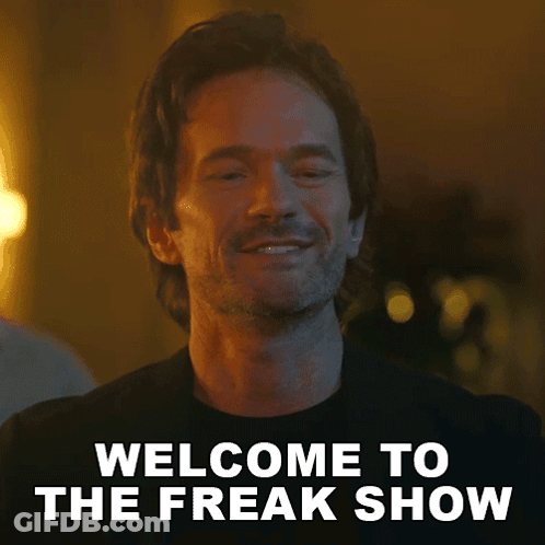 A Man With A Beard Is Smiling And Says Welcome To The Freak Show . GIF
