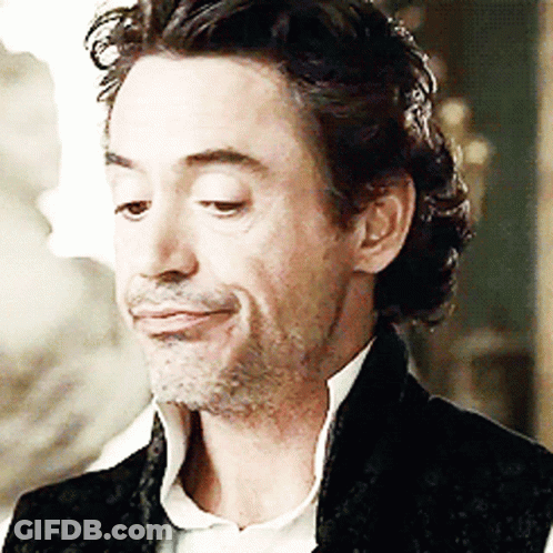 A Man With A Beard Is Smiling And Wearing A Black Jacket GIF