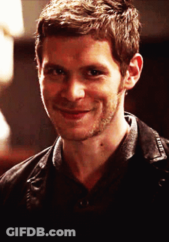 A Man With A Beard Is Smiling And Wearing A Black Shirt GIF