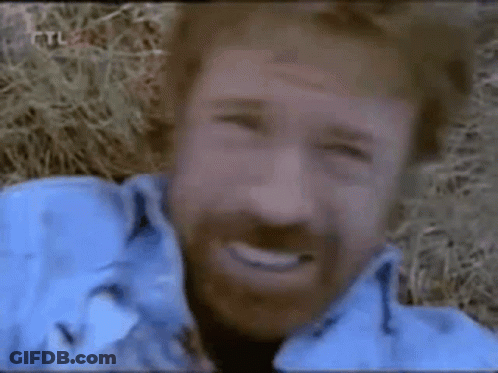 A Man With A Beard Is Smiling And Wearing A Blue Jacket . GIF