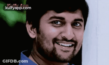 A Man With A Beard Is Smiling And Wearing A Blue Shirt GIF