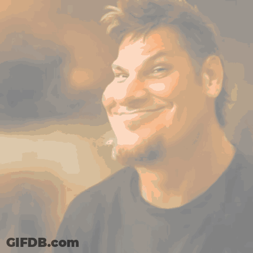 A Man With A Beard Is Smiling And Wearing A Green And Purple Shirt GIF