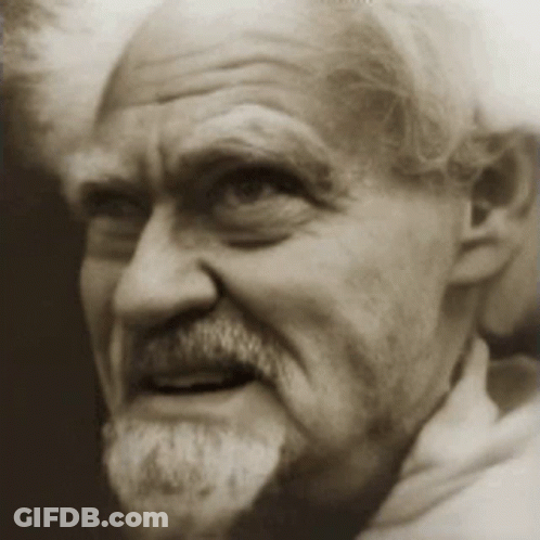 A Man With A Beard Is Smiling For The Camera In A Black And White Photo GIF
