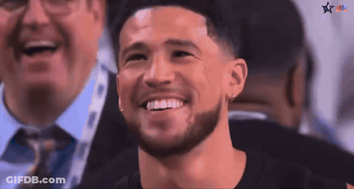 A Man With A Beard Is Smiling In A Crowd Of People GIF