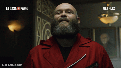 A Man With A Beard Is Smiling In A La Casa De Papel Advertisement GIF