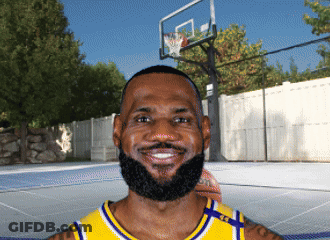 A Man With A Beard Is Smiling In Front Of A Basketball Court GIF