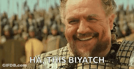 A Man With A Beard Is Smiling In Front Of A Crowd And Saying `` Ha , This Biyatch '' . GIF
