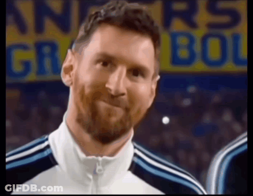 A Man With A Beard Is Smiling In Front Of A Sign That Says ' Argentina ' On It GIF