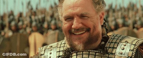 A Man With A Beard Is Smiling In Front Of Soldiers GIF