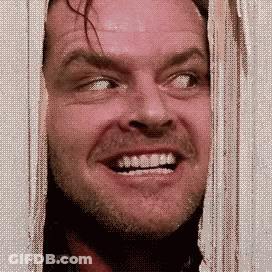 A Man With A Beard Is Smiling While Looking Out Of A Doorway . GIF
