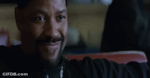A Man With A Beard Is Smiling While Sitting In A Car . GIF