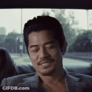 A Man With A Beard Is Smiling While Sitting In The Back Seat Of A Car GIF