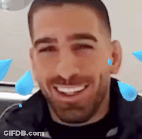A Man With A Beard Is Smiling With Blue Drops Of Water On His Face . GIF