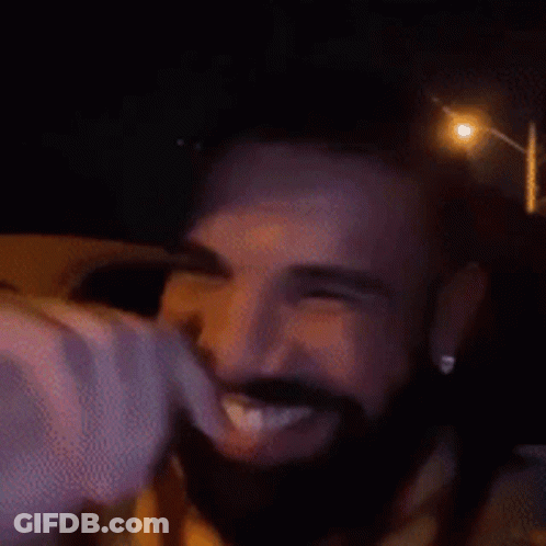 A Man With A Beard Is Smiling With His Eyes Closed And His Mouth Open . GIF