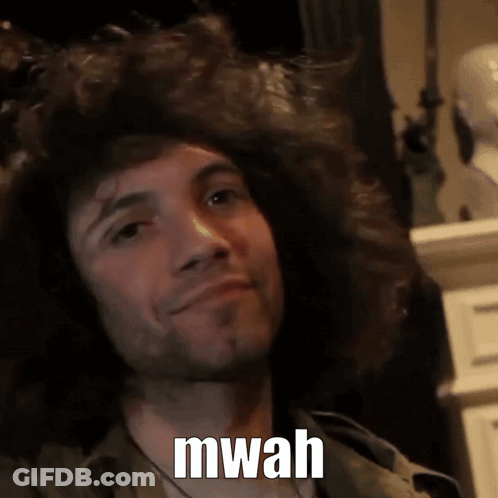 A Man With A Beard Is Smiling With The Words Mwah Written On His Face GIF