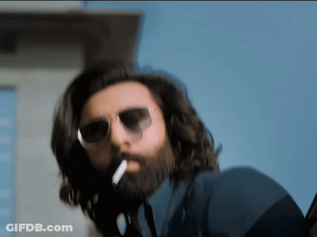 A Man With A Beard Is Smoking A Cigarette GIF