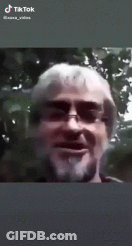 A Man With A Beard Is Smoking A Cigarette In A Tiktok Video . GIF