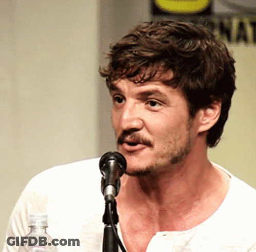 A Man With A Beard Is Speaking Into A Microphone While Holding A Bottle Of Water GIF