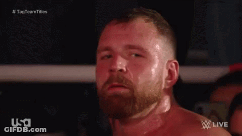 A Man With A Beard Is Standing In A Boxing Ring Looking At The Camera . GIF
