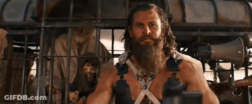 A Man With A Beard Is Standing In A Cage With Other People GIF