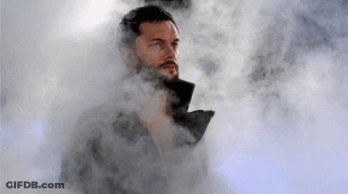 A Man With A Beard Is Standing In A Cloud Of Smoke GIF